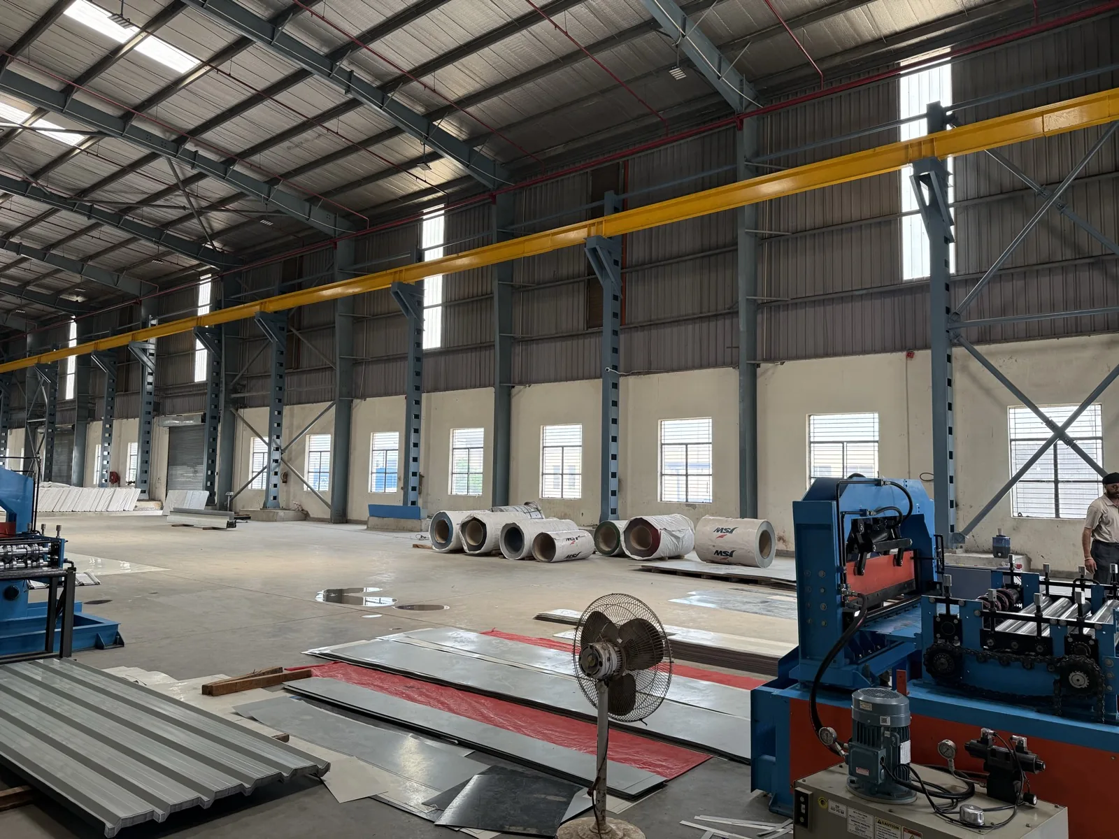 Galvanized and colour-coated steel coil stock on the floor