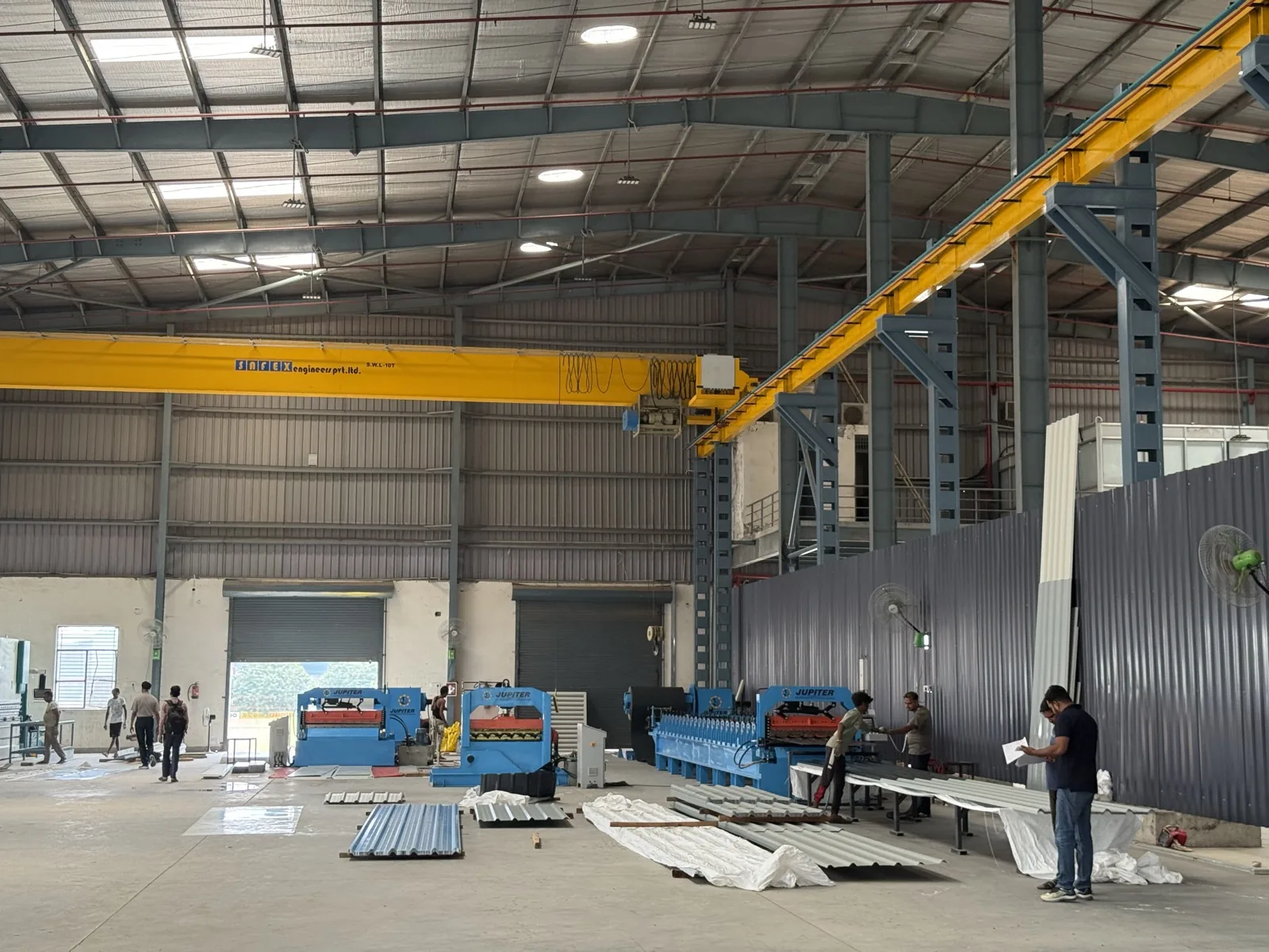 Overhead gantry cranes spanning the roll-forming bay